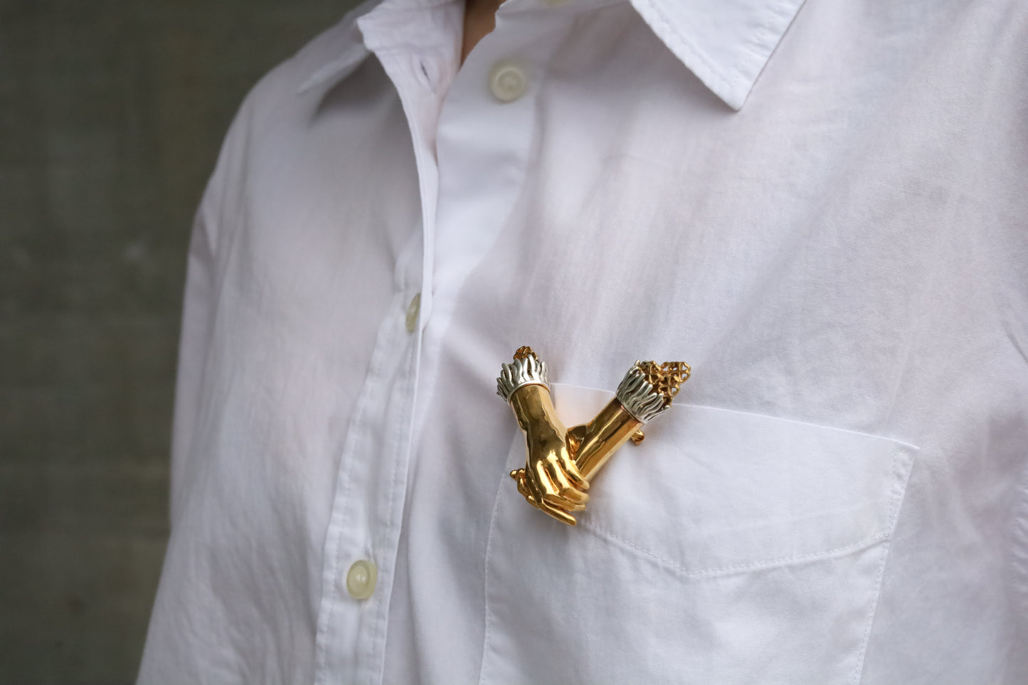 Jenna London gold brooch on a white shirt against a neutral background
