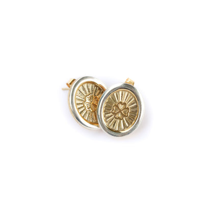 Gold circular earrings with intricate designs on a white background