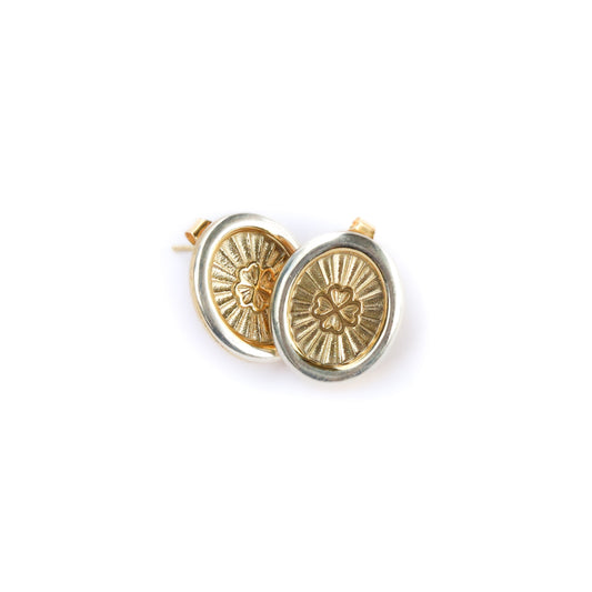 Gold circular earrings with intricate designs on a white background
