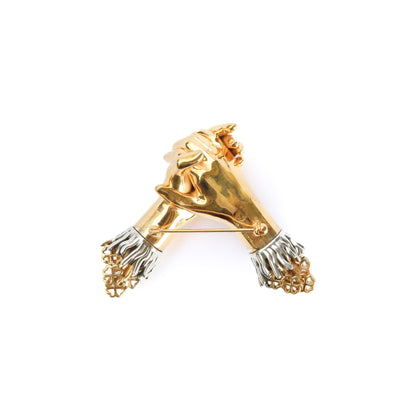 Gold and silver lion head brooch on a white background