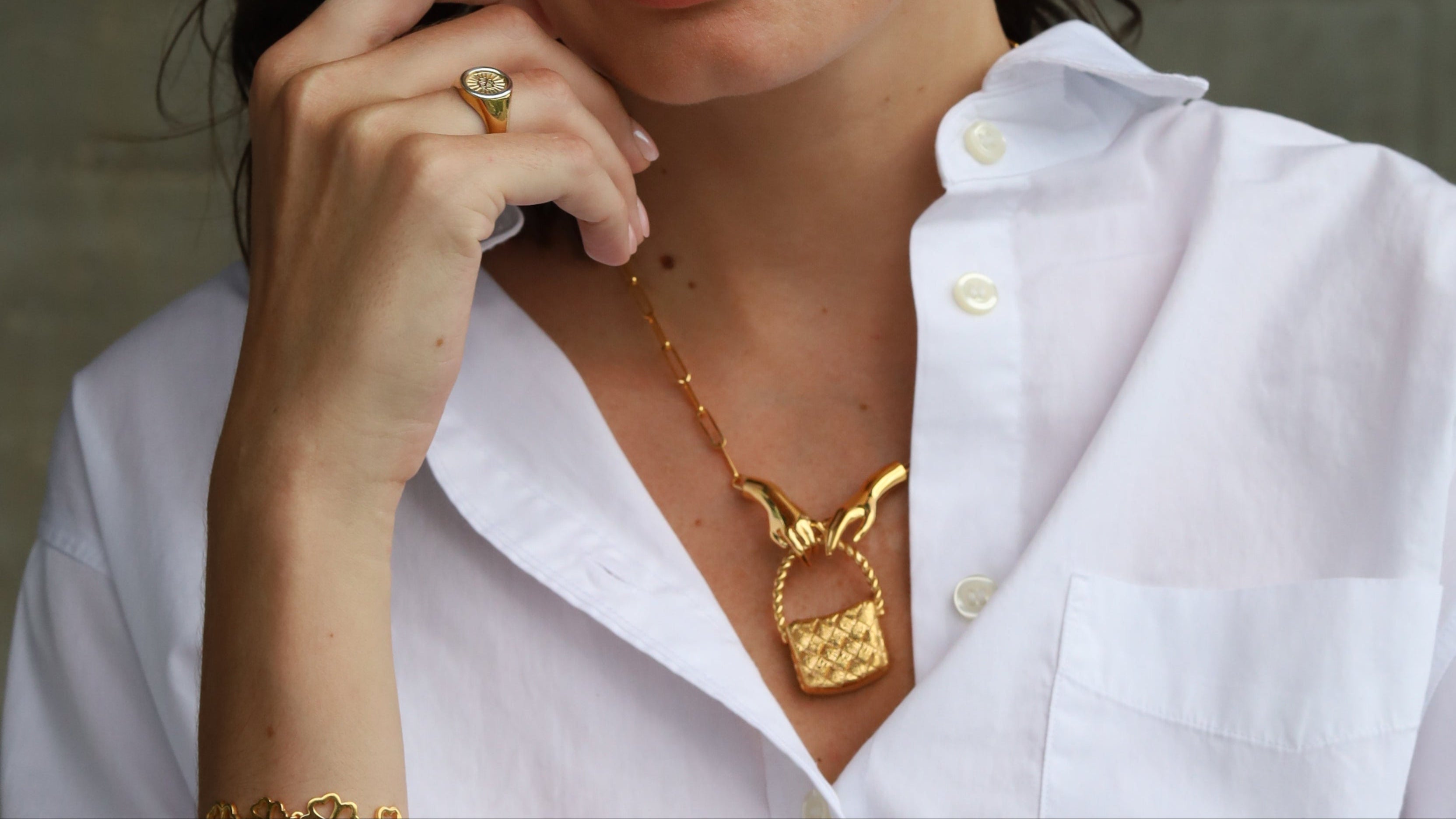 Woman wearing gold jewelry against a neutral background