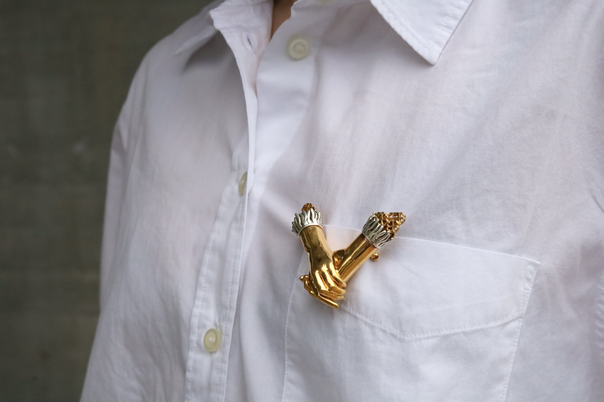 Jenna London gold brooch on a white shirt against a neutral background