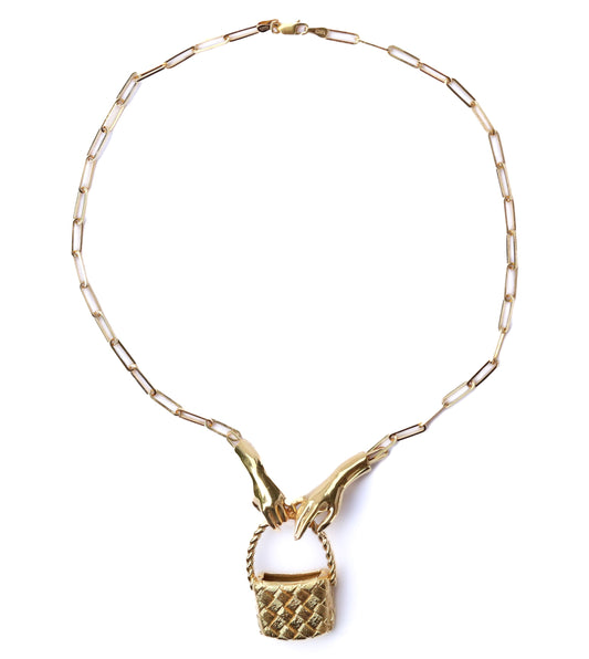 Gold necklace with a basket pendant on a white background