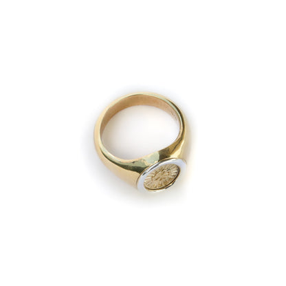 Gold ring with a circular design on a white background