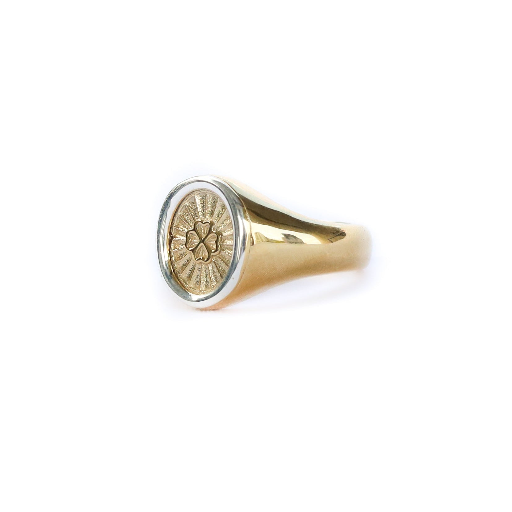 Gold ring with a circular emblem on a white background
