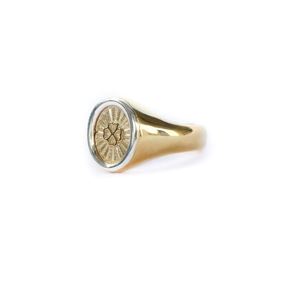 Gold ring with a circular emblem on a white background